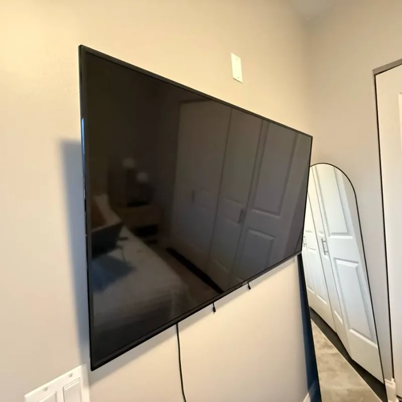 75-inch TV wall mounted in a Chicago apartment bedroom