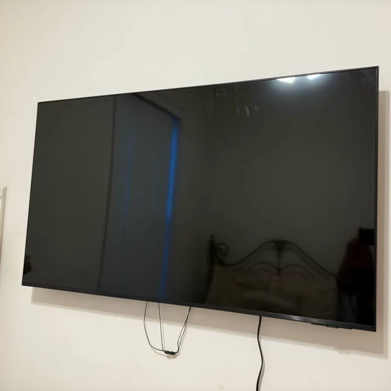 Large TV wall mounted in a Chicago bedroom with cables bundled below