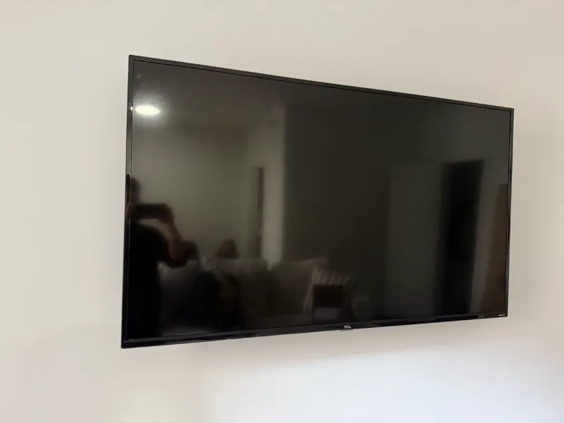 TCL Roku TV wall mounted in a Chicago living room