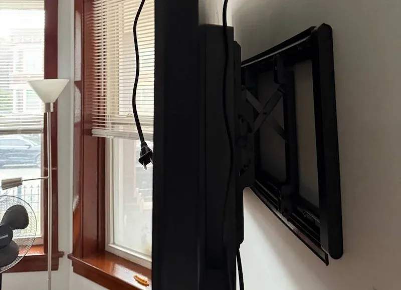 Tilting TV mount installed in a vintage Chicago apartment with wood trim