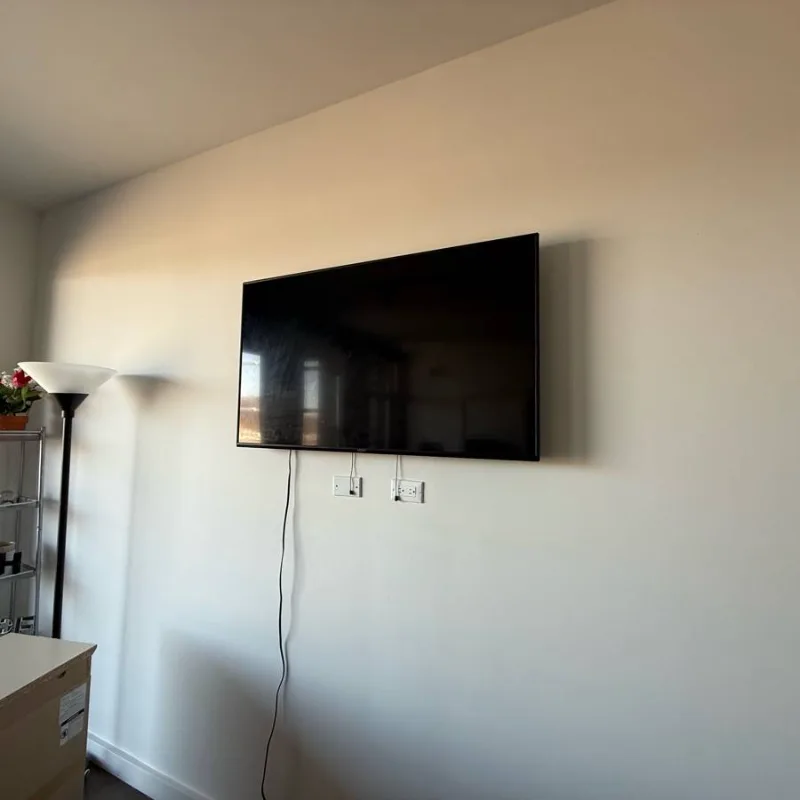 TV wall mounted above the outlets in a Chicago studio apartment