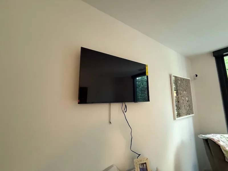 TV wall mounted in a Chicago bedroom next to framed artwork